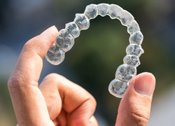 a person holding Invisalign aligners