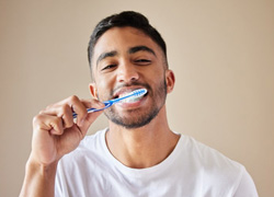 a man happily brushing his teeth
