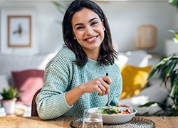 Woman smiling while eating healthy meal at home