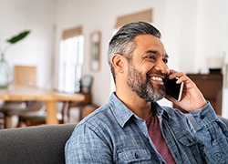Man smiling while talking on phone at home