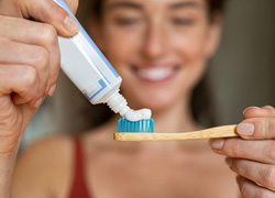 Woman putting toothpaste on her toothbrush