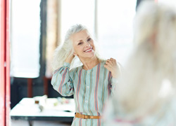 Woman looking at a mirror while getting ready for the day