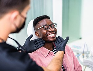 Dentist looking at patient's smile in treatment room