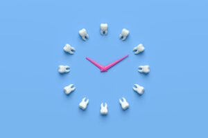 12 teeth arranged in a circle with pink clock hands on a blue background