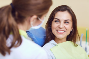 Woman smiling as she asks her dentist questions