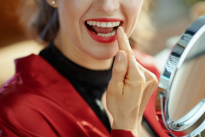 Close up of woman checking out her dental bonding in her mirror